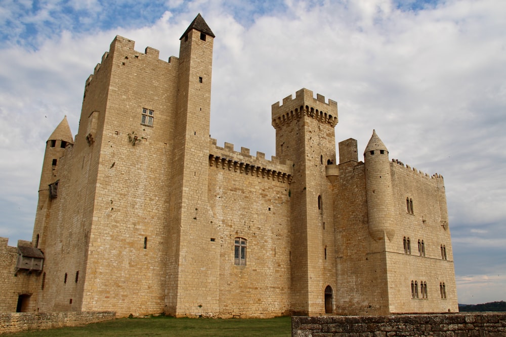 brown concrete castle under cloudy sky during daytime