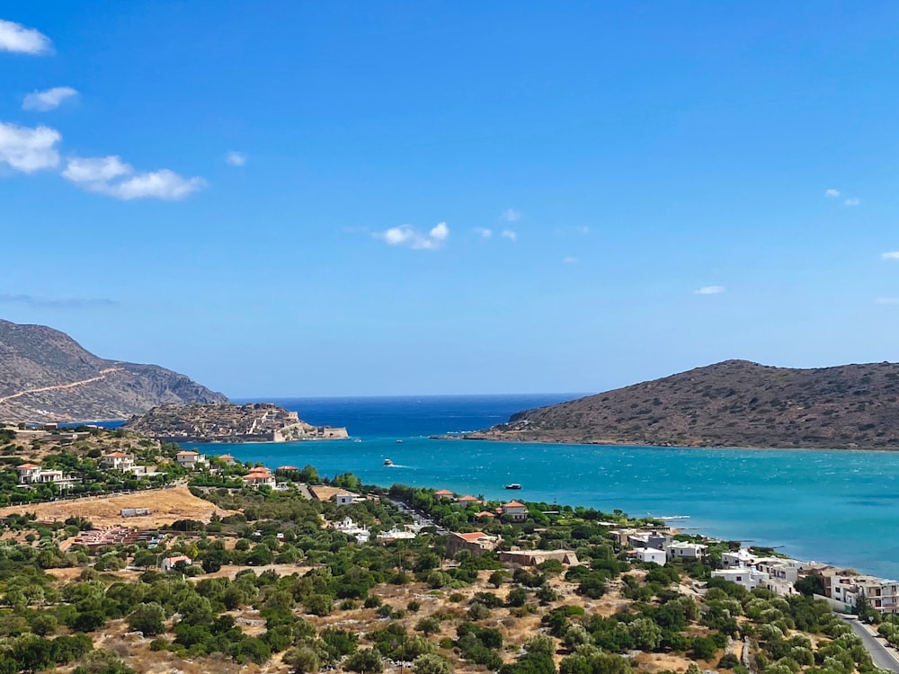 green and brown mountains near blue sea under blue sky during daytime