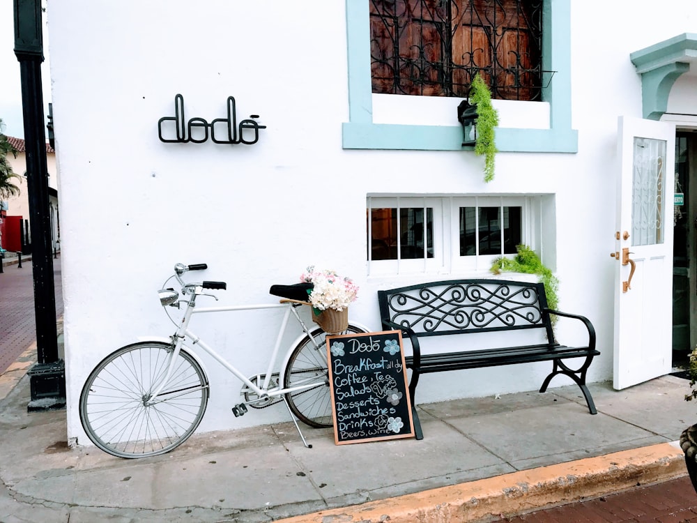 black city bike parked beside white wall