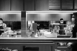 Photo showing a group of enthusiastic cafe staff learning beverage techniques in a professional class.
