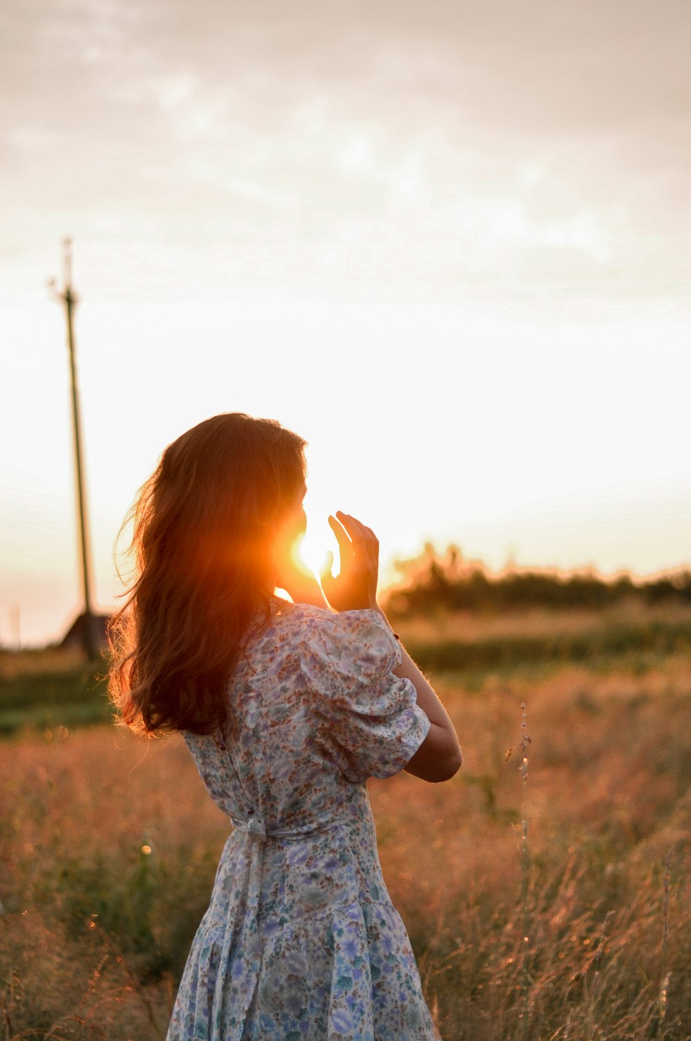 girl in blue and white floral dress standing on green grass field during daytime