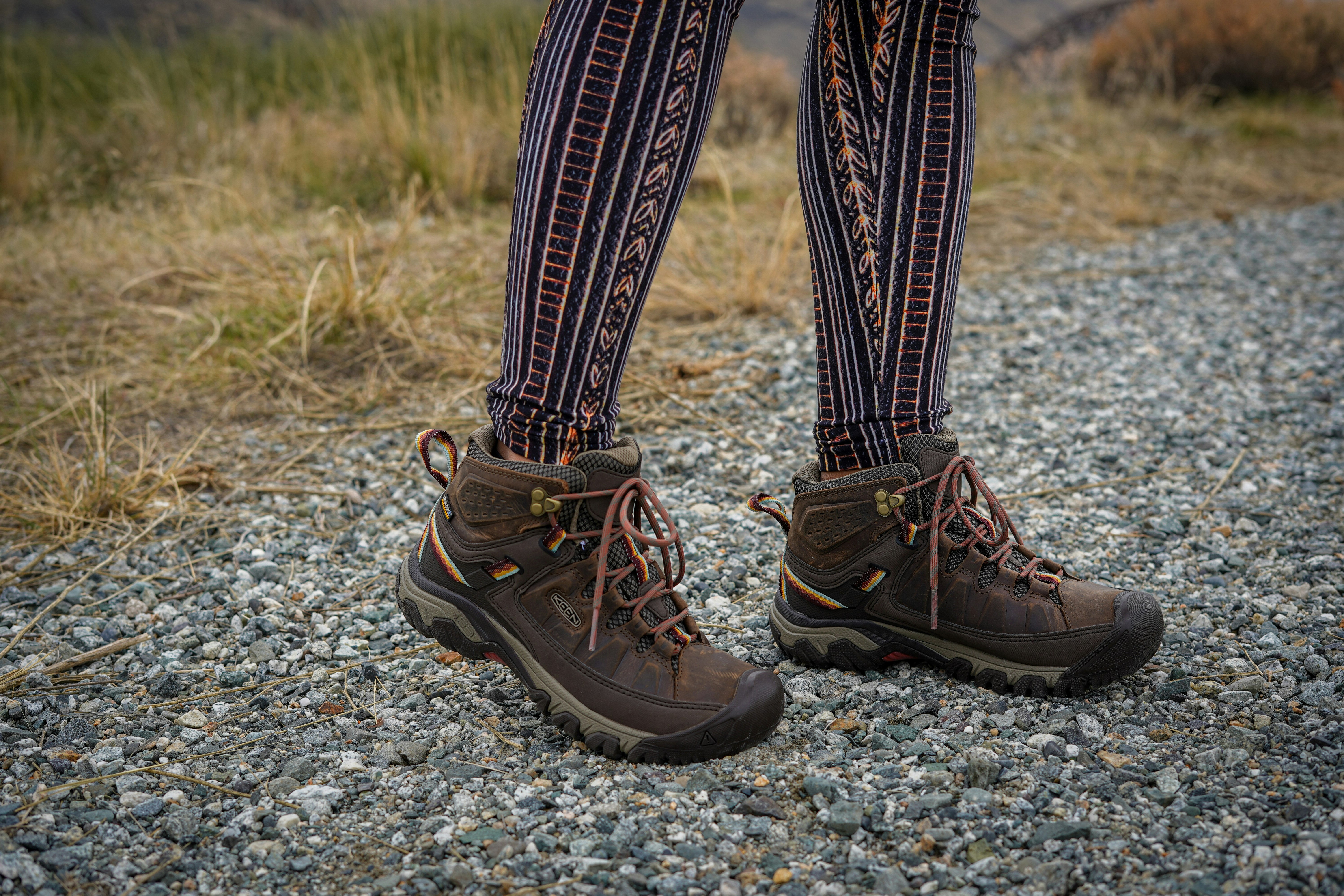 person wearing black leather hiking boots
