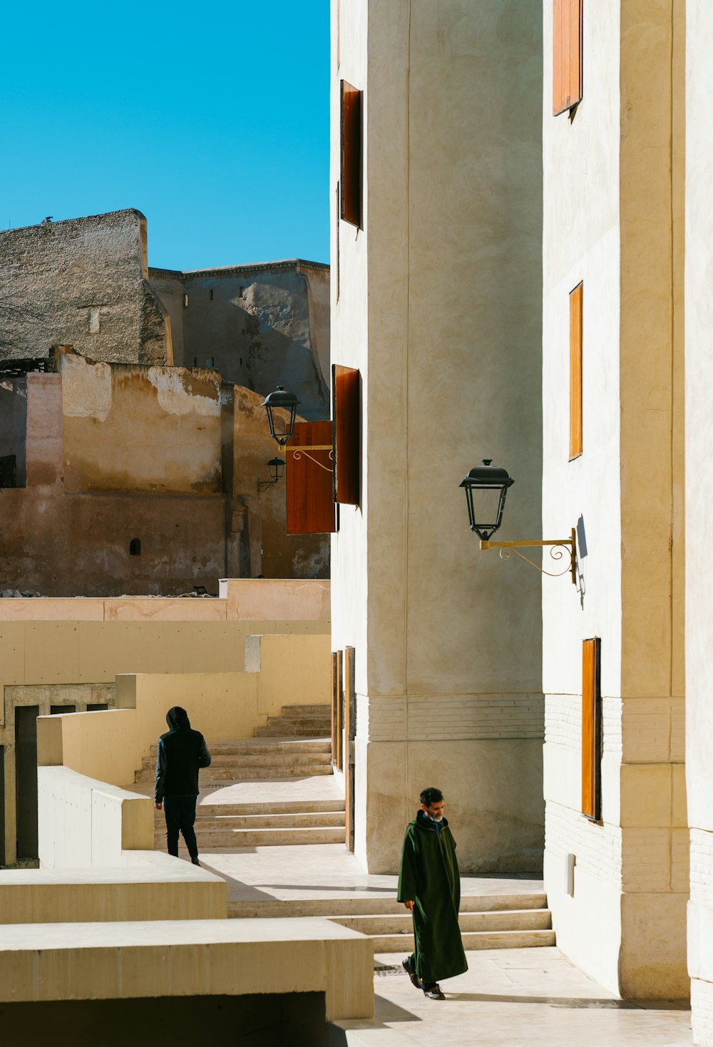 man in black jacket walking on sidewalk during daytime