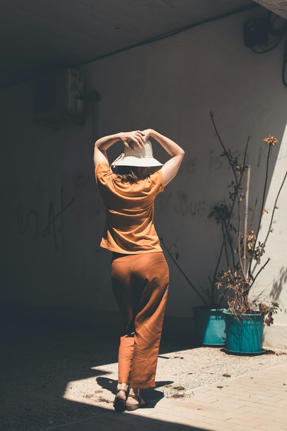 donna in abito senza maniche marrone in piedi sul pavimento di legno marrone