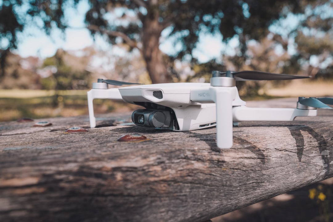 white and black drone on brown wooden table,