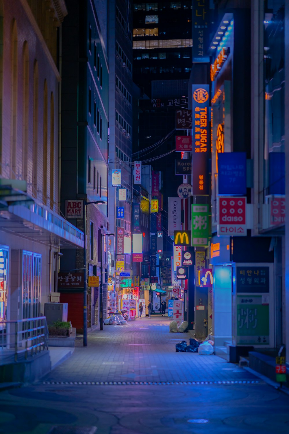 people walking on sidewalk near buildings during night time