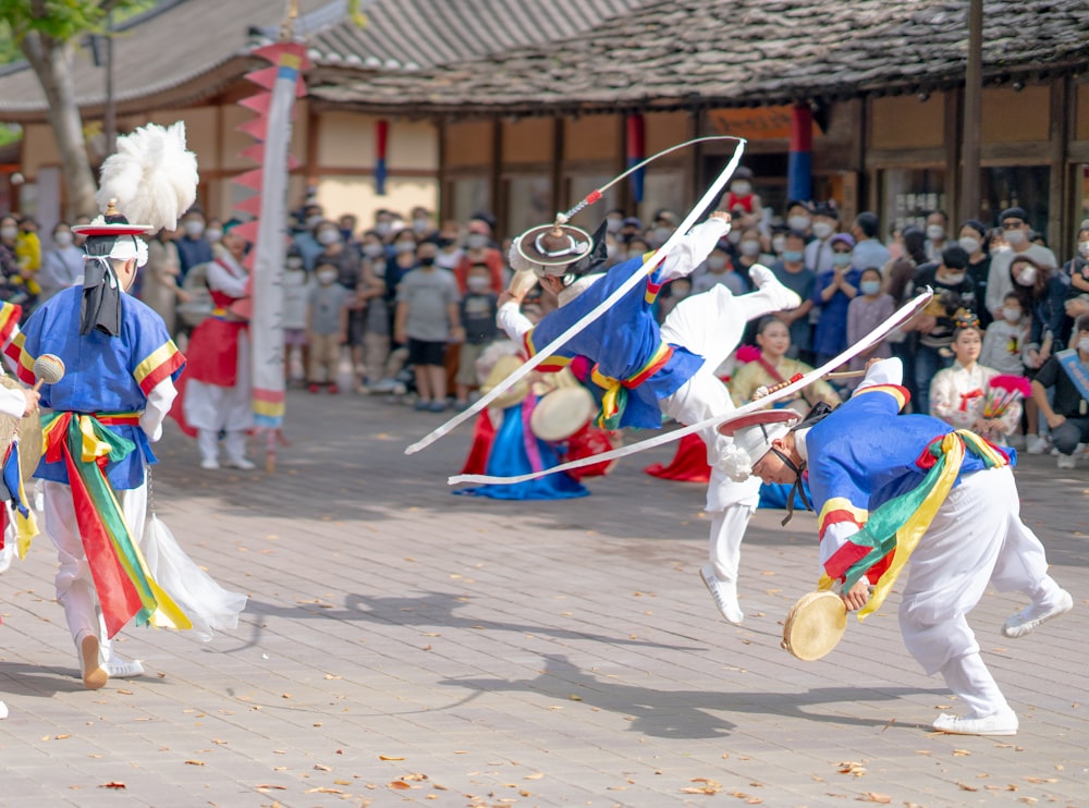 people in blue and white costume dancing on street during daytime