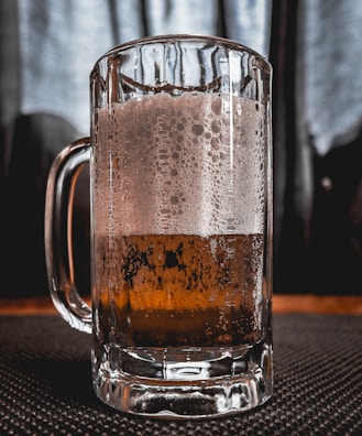 Close-up of a frosty beer mug with condensation on the glass.