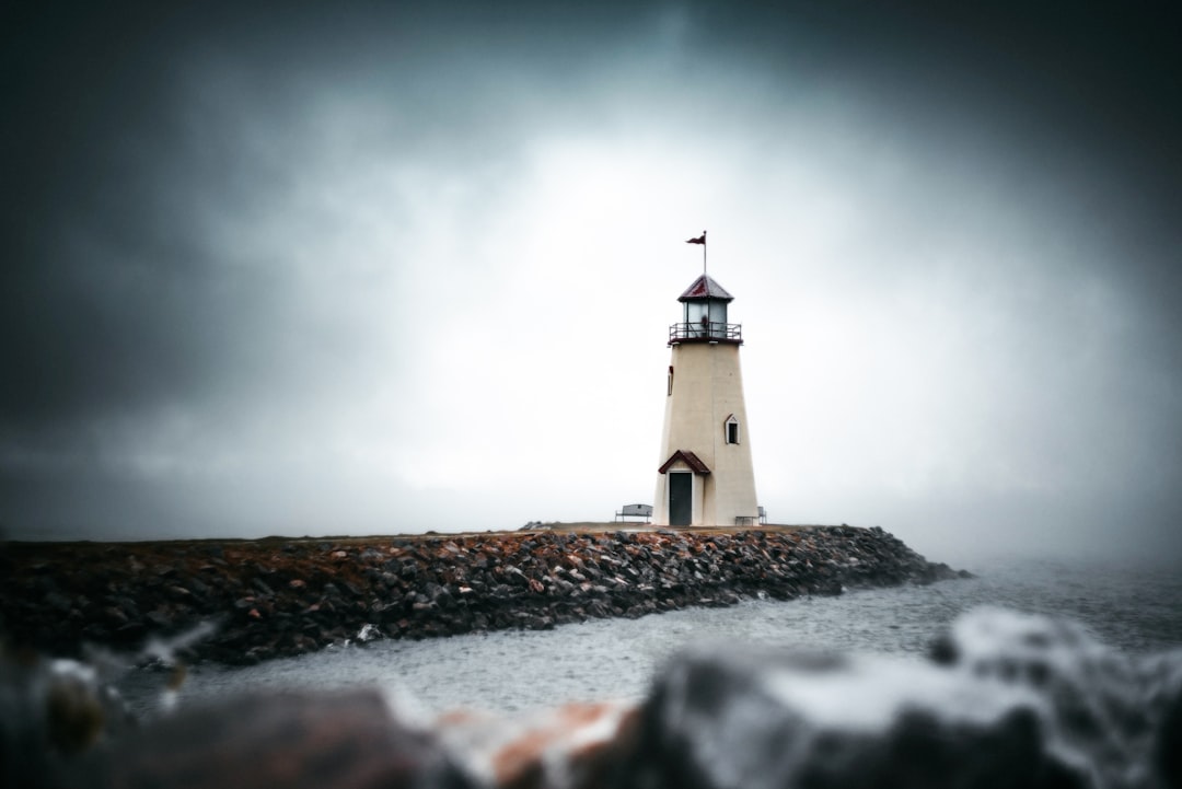 white and black lighthouse under gray sky