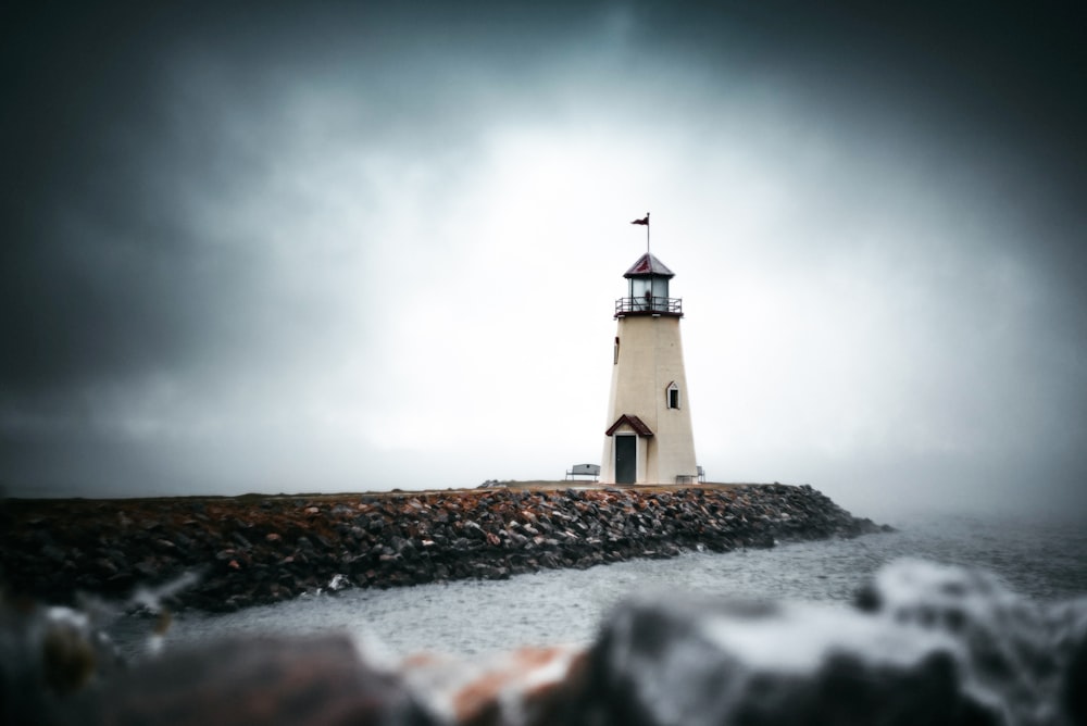 white and black lighthouse under gray sky
