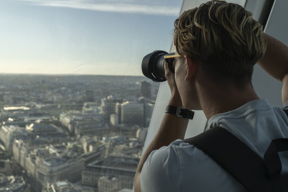 man in black t-shirt using binoculars during daytime