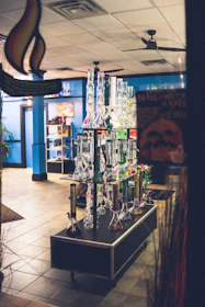 A friendly shop assistant helping a customer choose from an array of smoking accessories.