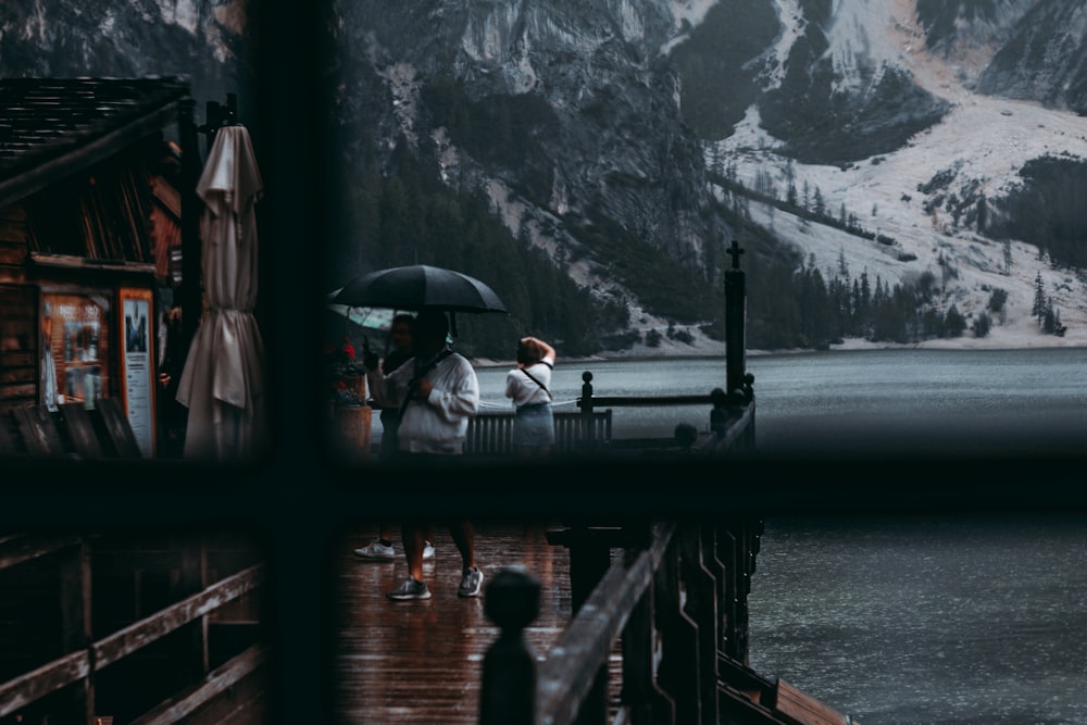 people walking on bridge near mountain during daytime