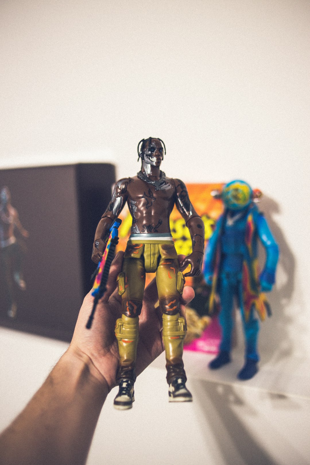 person holding blue and yellow robot action figure