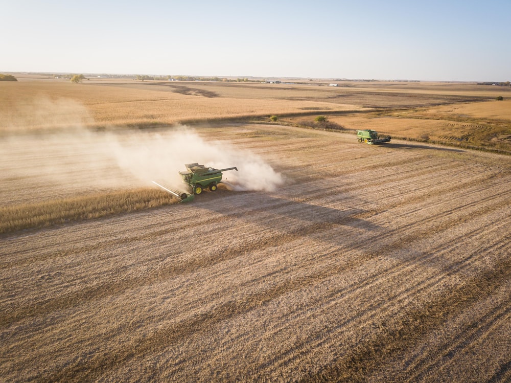 green and black heavy equipment on brown field during daytime