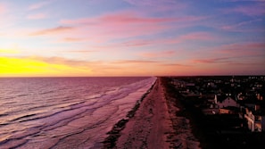 A vibrant sunset over the pristine coastline near Sancang.