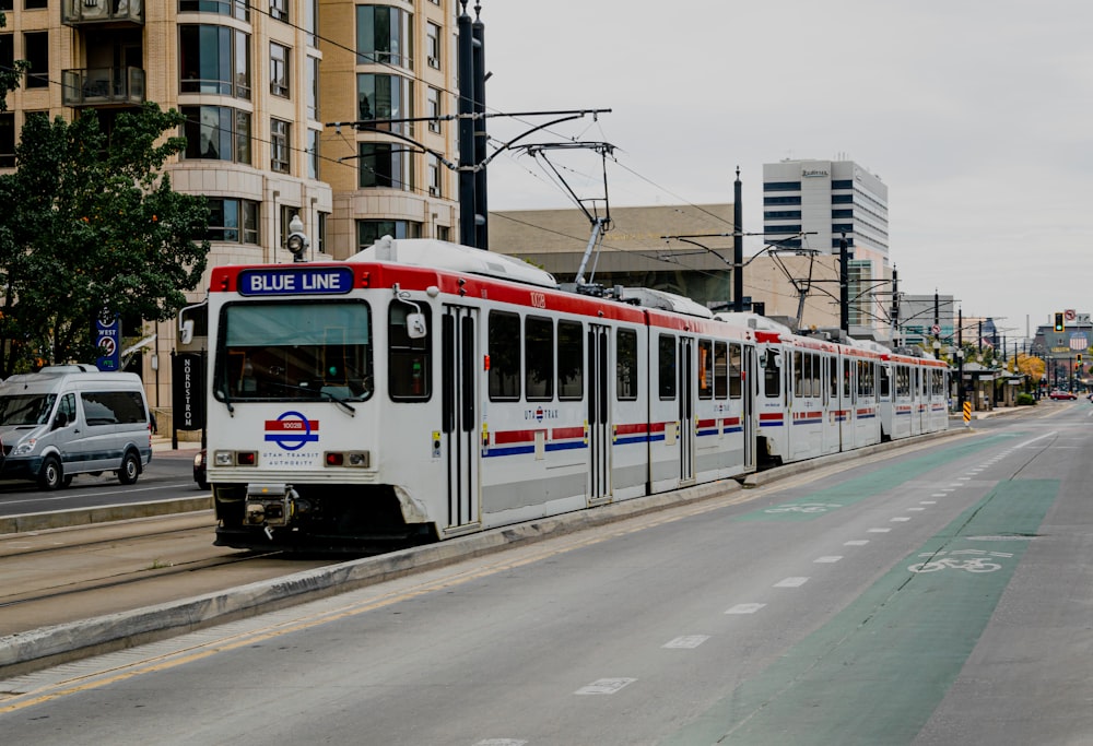 Tram blanc et rouge sur la route pendant la journée