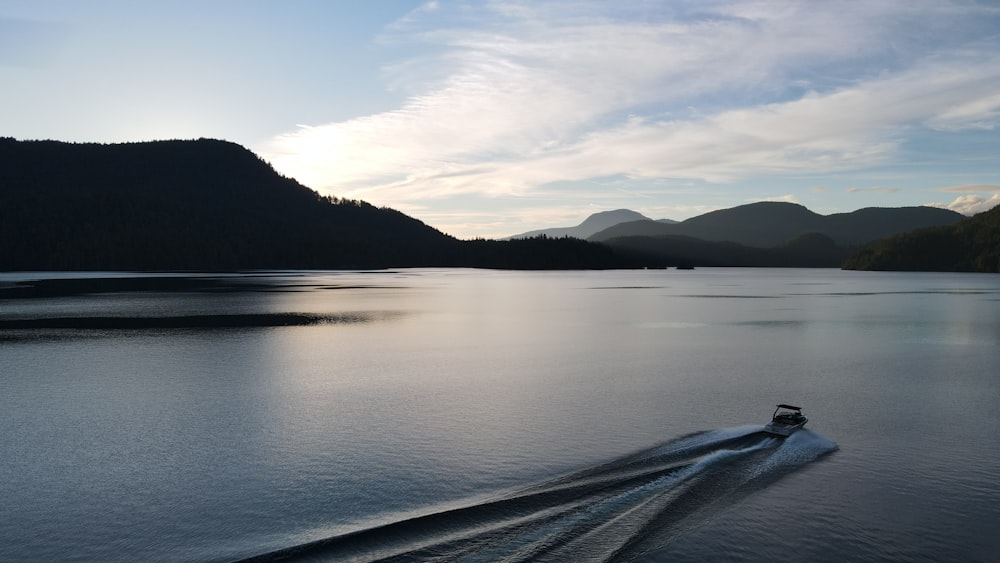 body of water near mountain during daytime