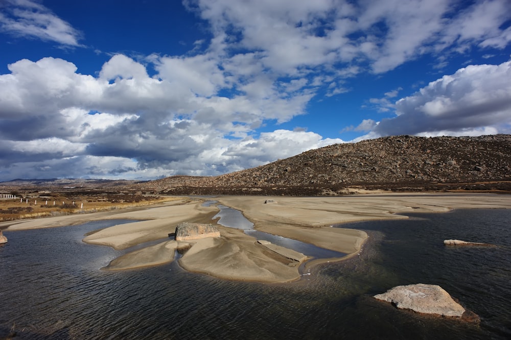 Campo marrón bajo cielo azul y nubes blancas durante el día