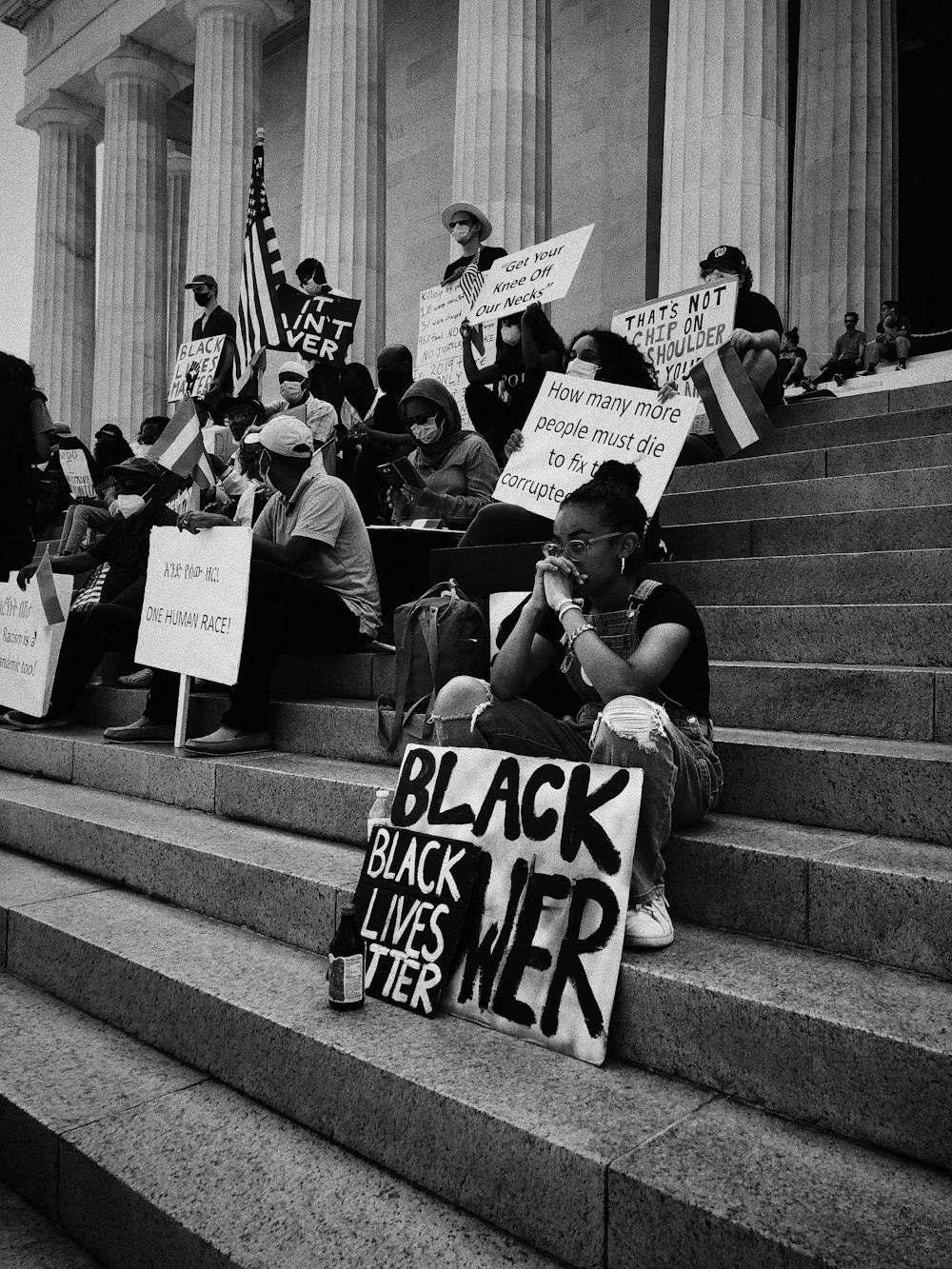 grayscale photo of people sitting on stairs