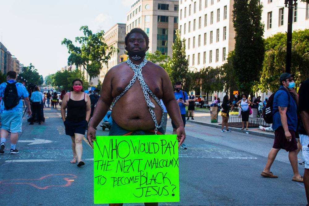 woman in blue and white bikini holding green and black signage