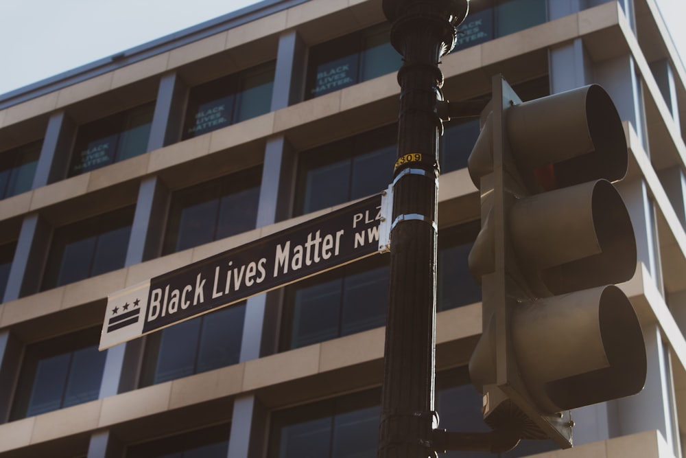 black street light near white concrete building during daytime