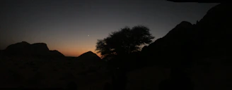 A serene landscape of Helper, Utah at dusk, with faint orbs of light captured in the sky.