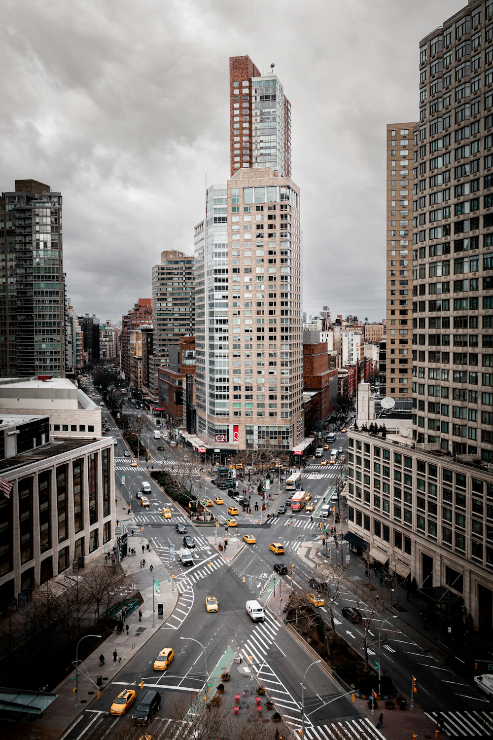 cars on road between high rise buildings during daytime