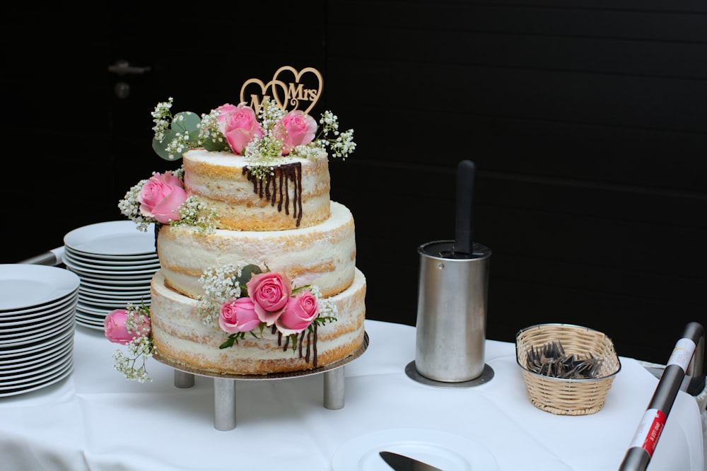 Tarta de 3 capas con flores rosadas en la parte superior