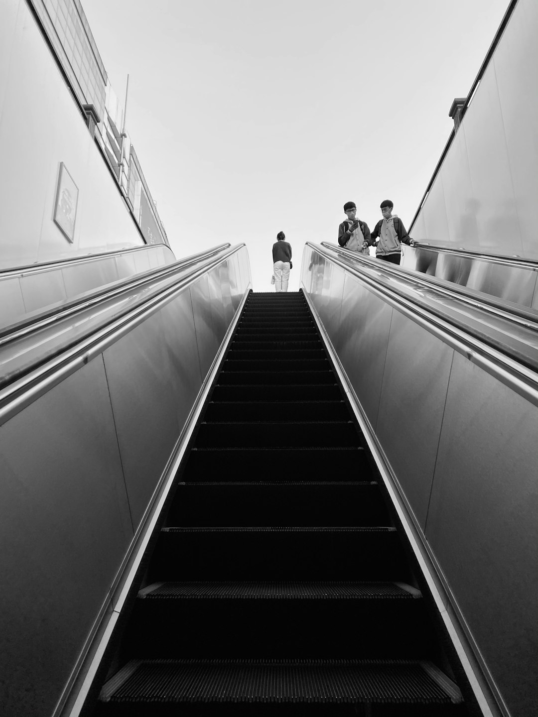 grayscale photo of people walking on stairs