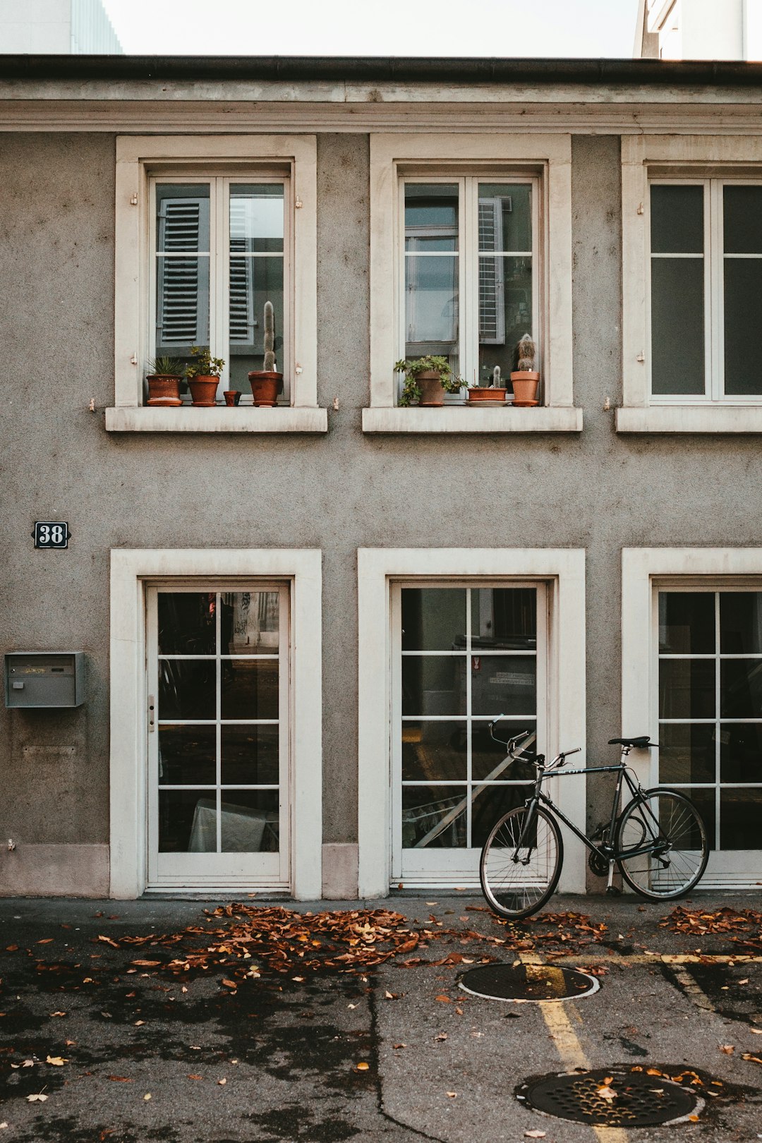 black bicycle parked beside white concrete building