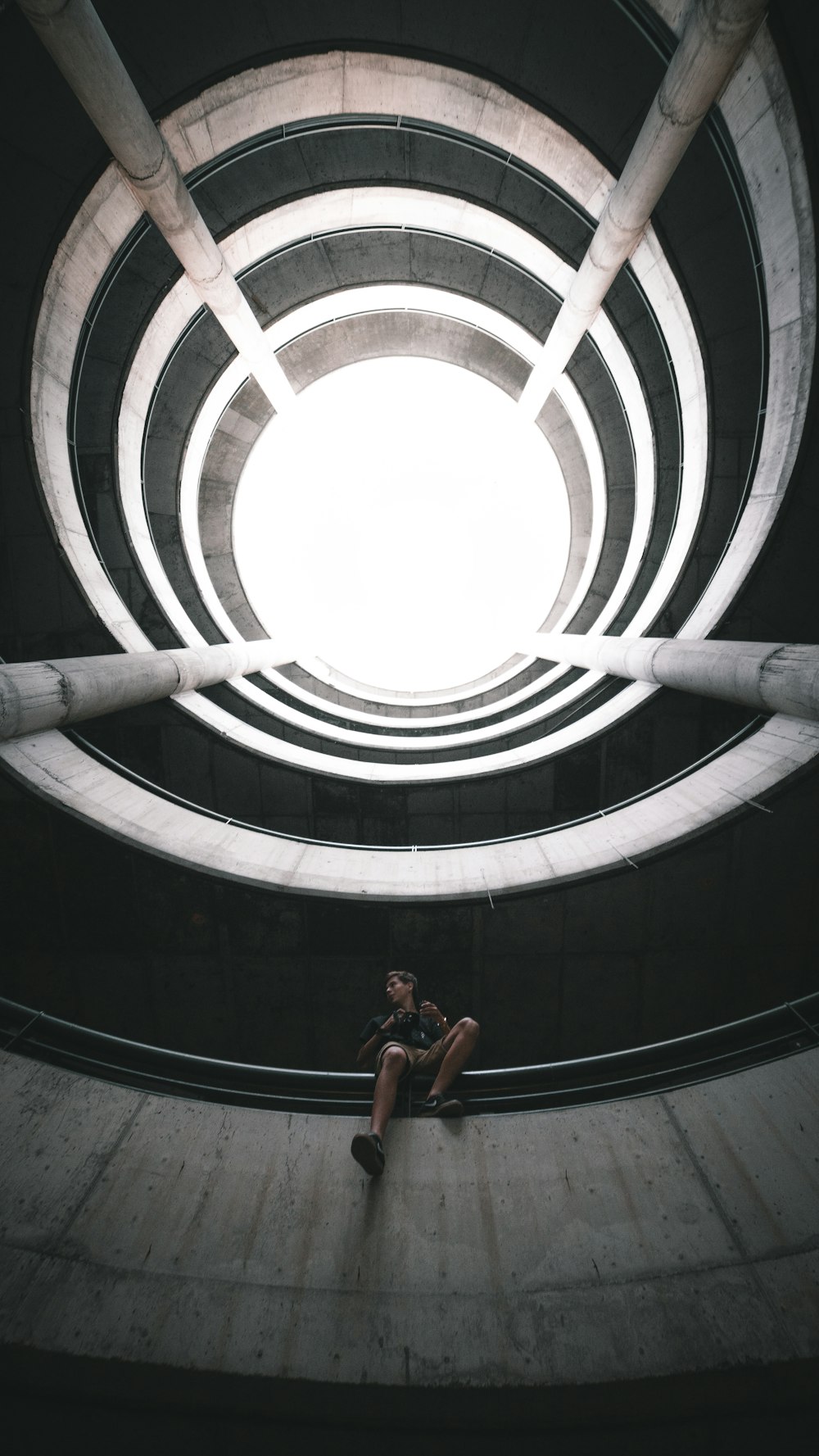 woman in black tank top and black shorts standing on spiral staircase