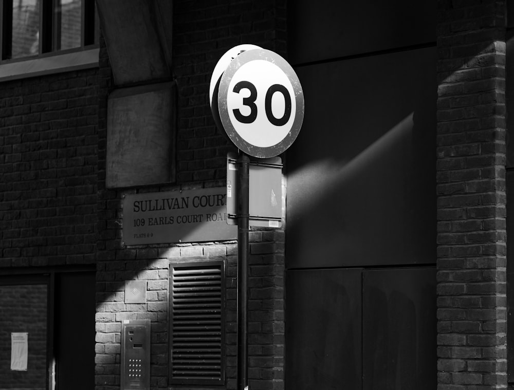 grayscale photo of a round and number 6 sign