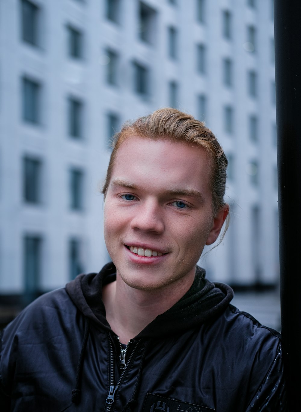 smiling man in black zip up jacket