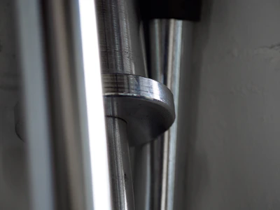 Rows of polished metal rods reflecting the overhead lights in a clean manufacturing plant.