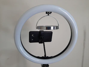 A vibrant ring light illuminating a cozy streaming corner with a laptop and camera.