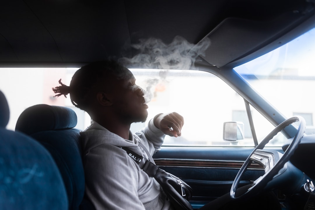 man in white shirt driving car