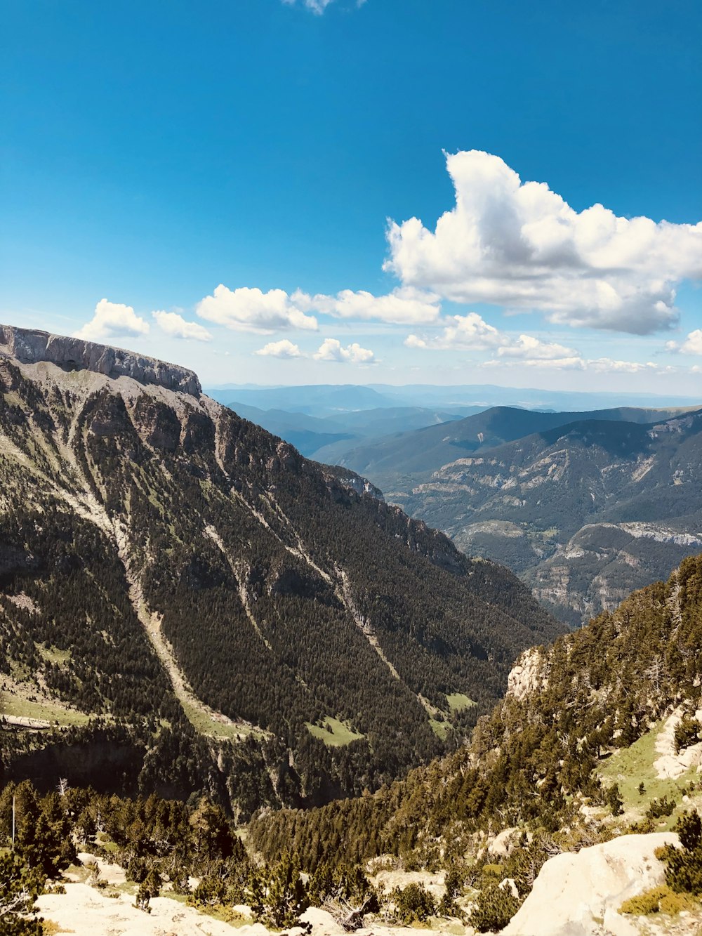 montagne verdi e marroni sotto il cielo blu durante il giorno