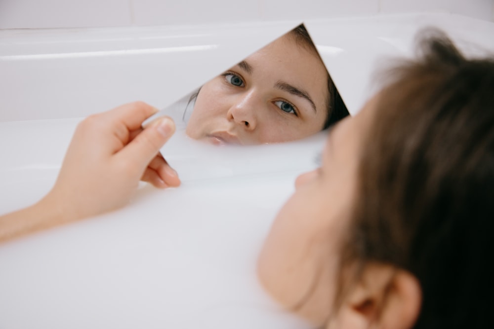 girl lying on white bathtub