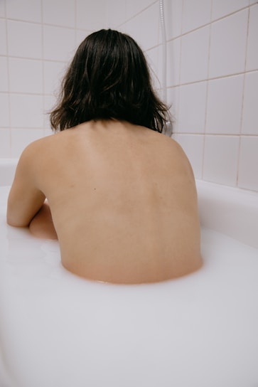 naked woman on white bathtub