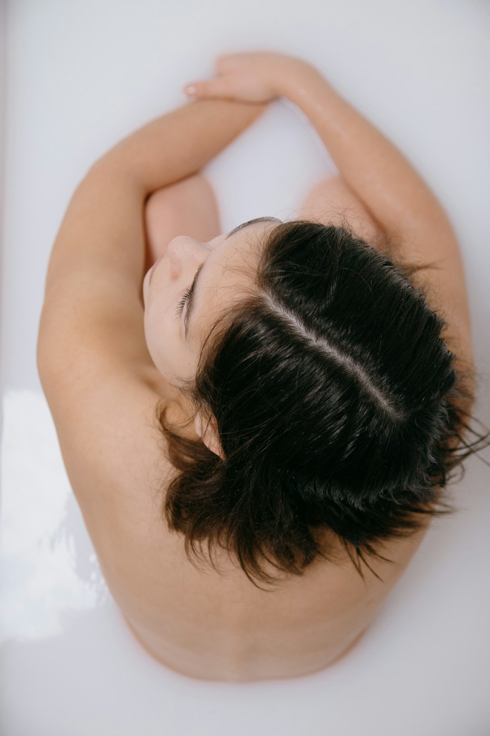 woman lying on white bathtub