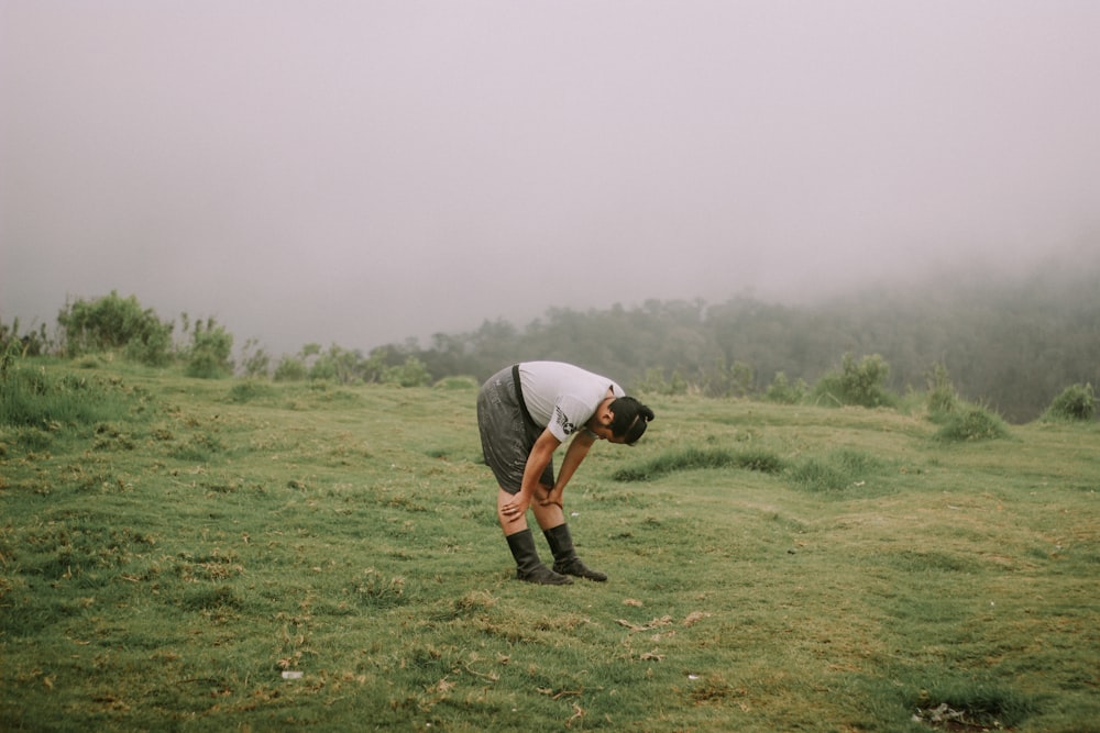 man in gray t-shirt and black shorts playing golf during daytime