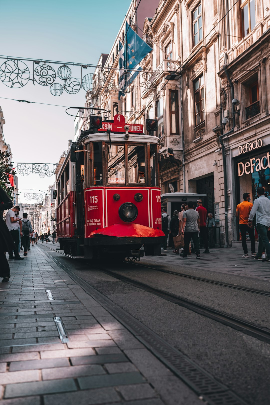 red tram on the street during daytime