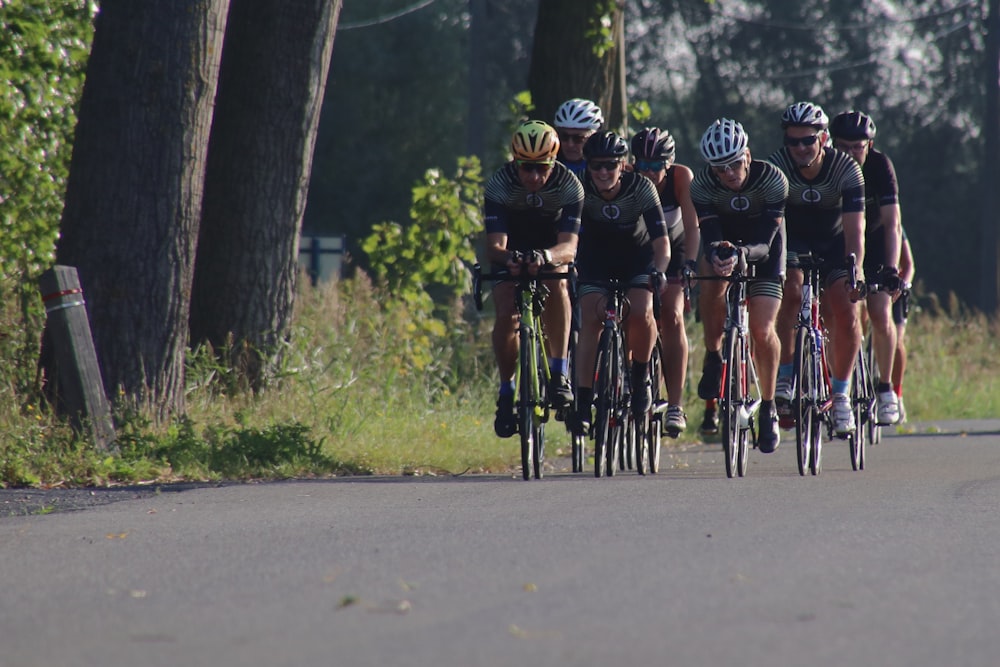 men riding bicycle on road during daytime