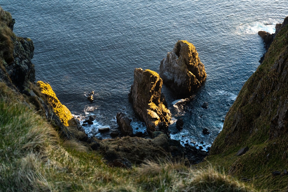 brown rock formation on body of water during daytime