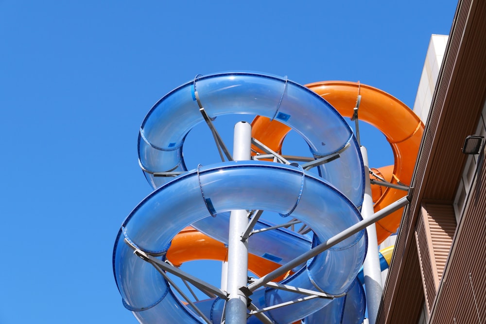 ruota panoramica arancione e grigia sotto il cielo blu durante il giorno