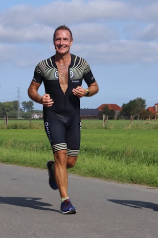 Man running outdoors wearing a breathable tracksuit with flexible fit details visible.