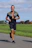A man jogging outdoors with a confident and happy expression on his face.