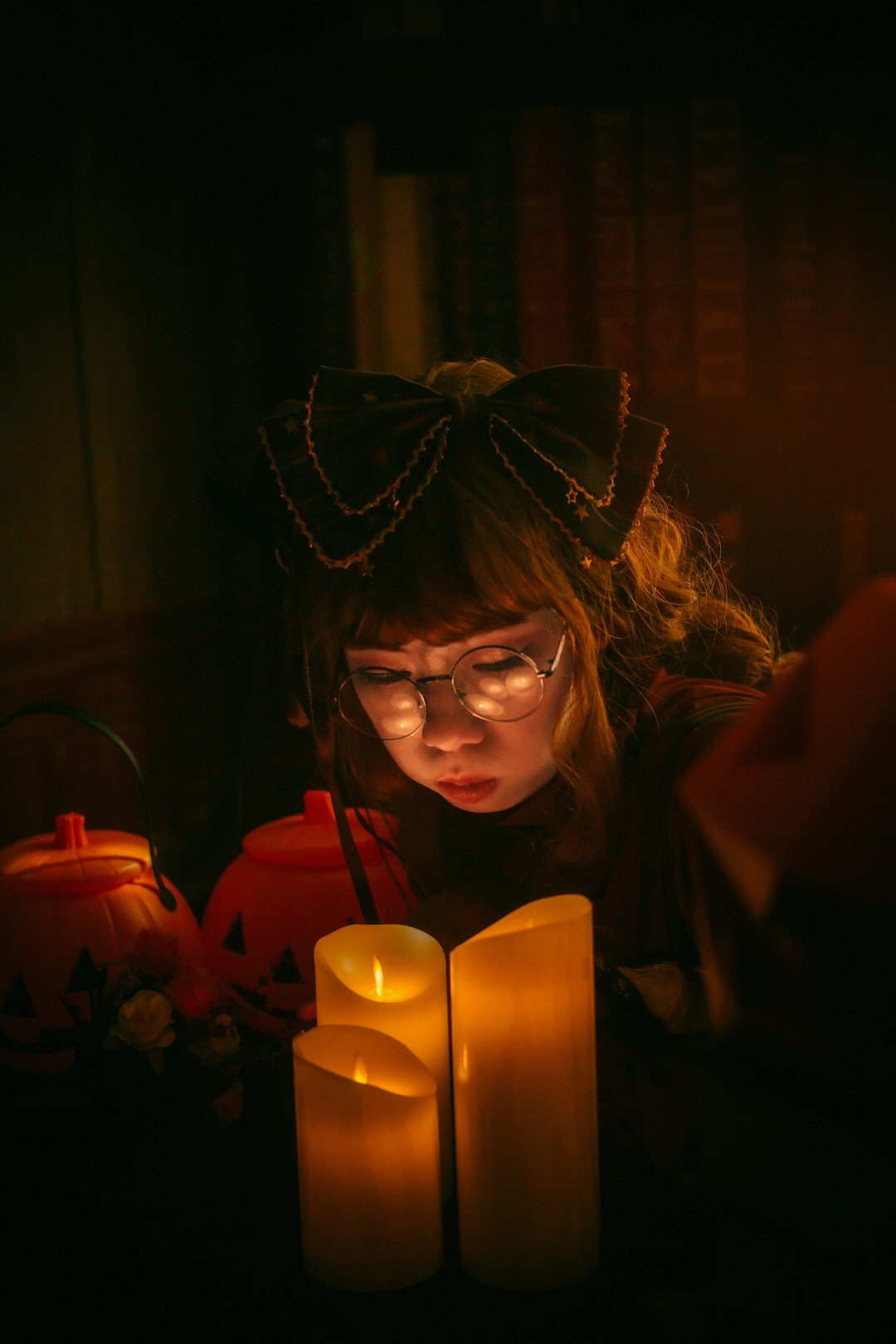 woman in black framed eyeglasses holding lighted candle