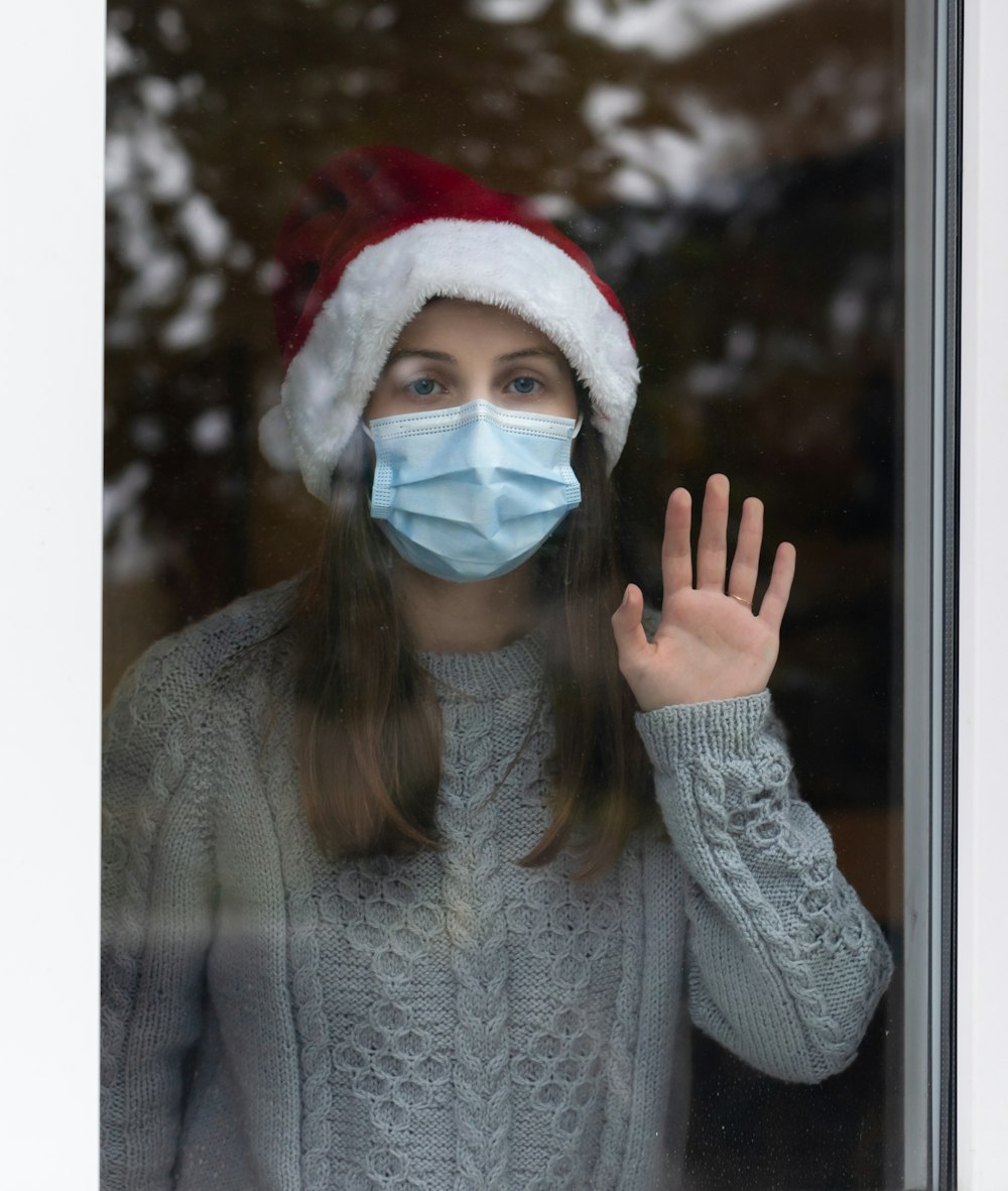 woman in gray sweater wearing white mask